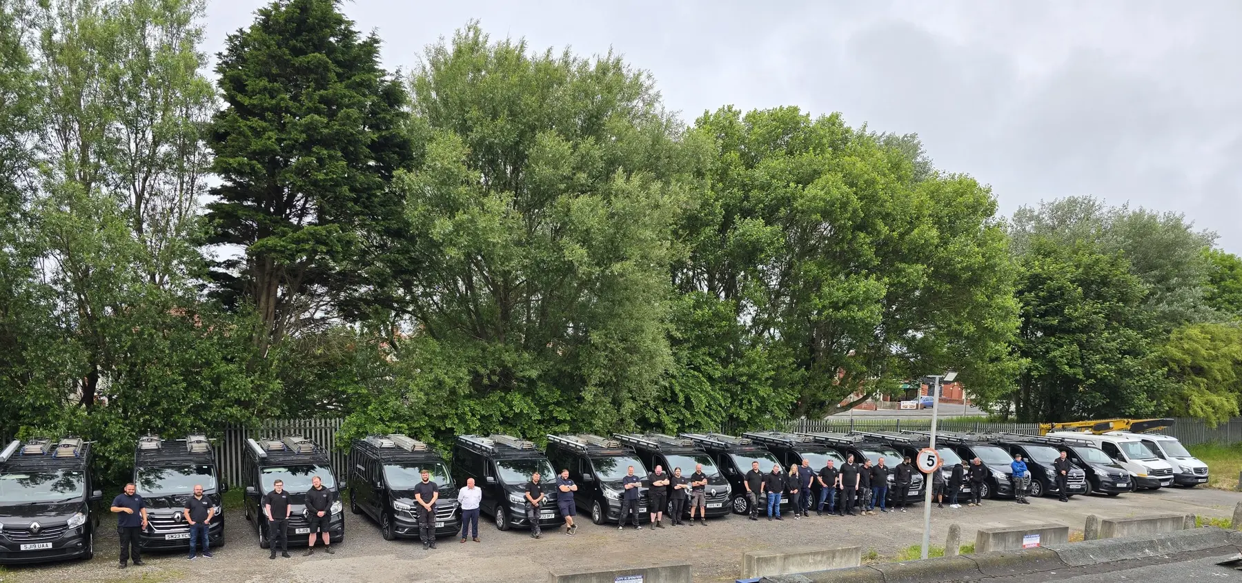 The AD Systems team standing together with the company vehicle fleet